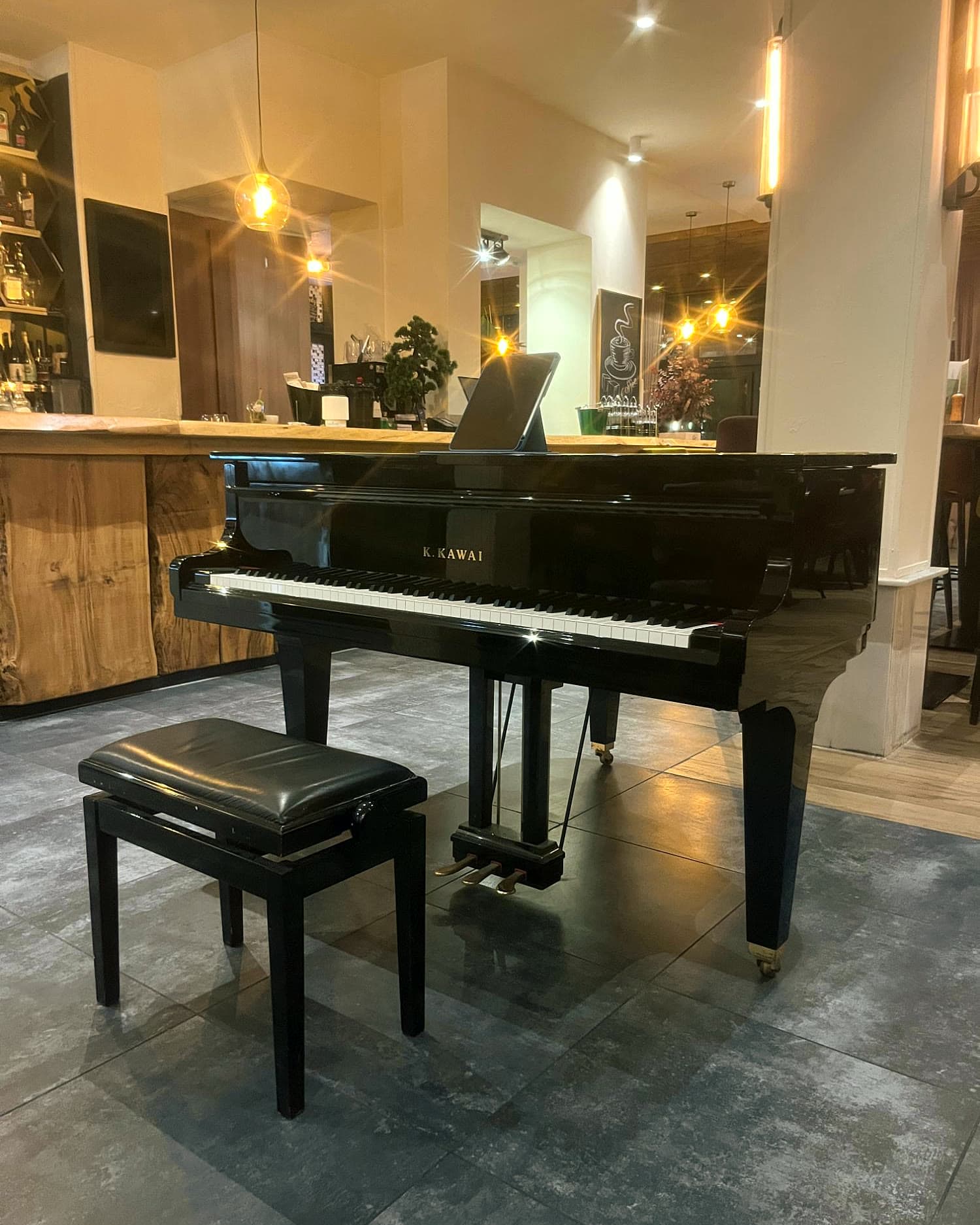 Grand piano at Namos in Cologne, with the bar behind it